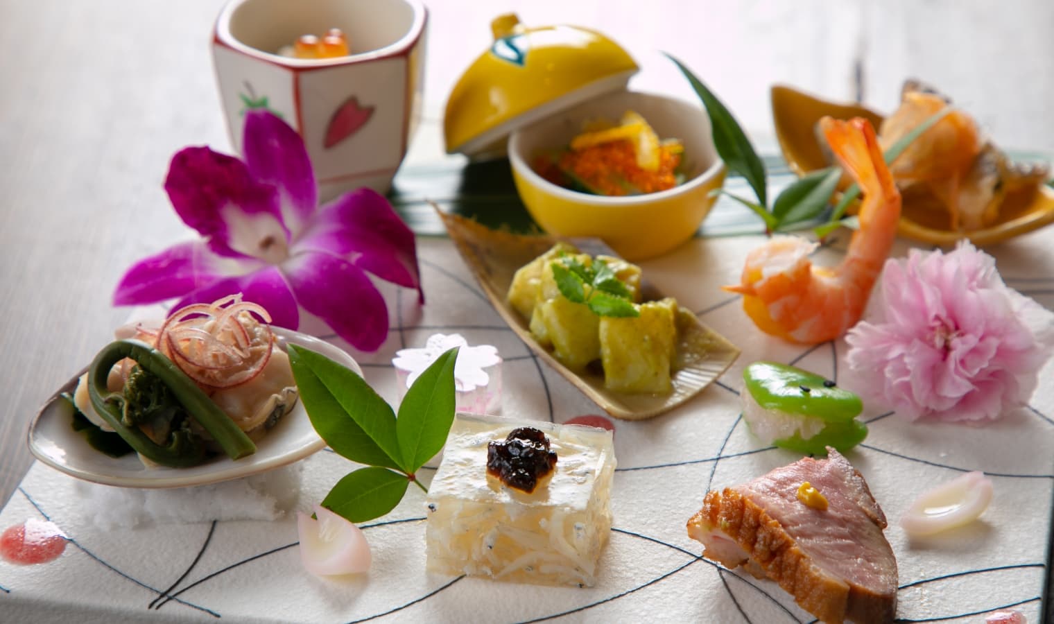 Seasonal kaiseki appetizer plate with sashimi, shrimp and edible flowers at the Yufuin ryokan