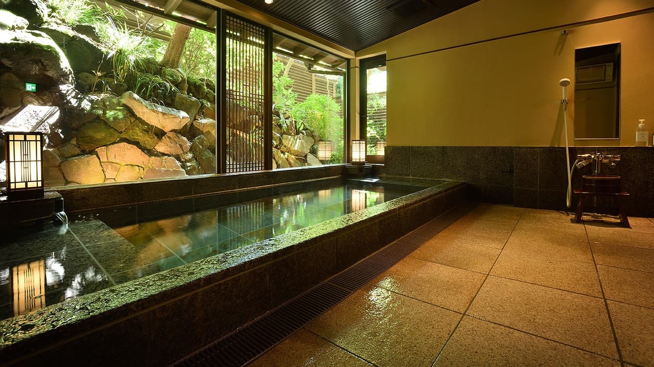Open-air wooden bath with a green forest view through the window
