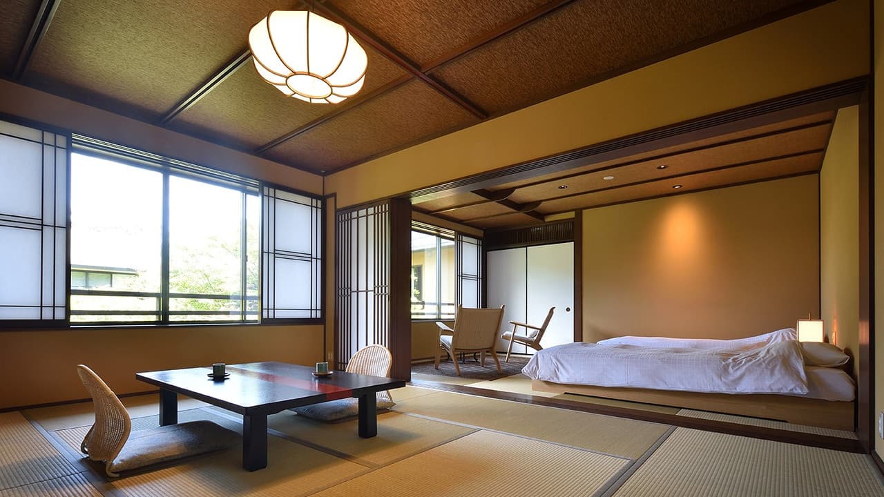 Spacious tatami suite with a bed and low dining table