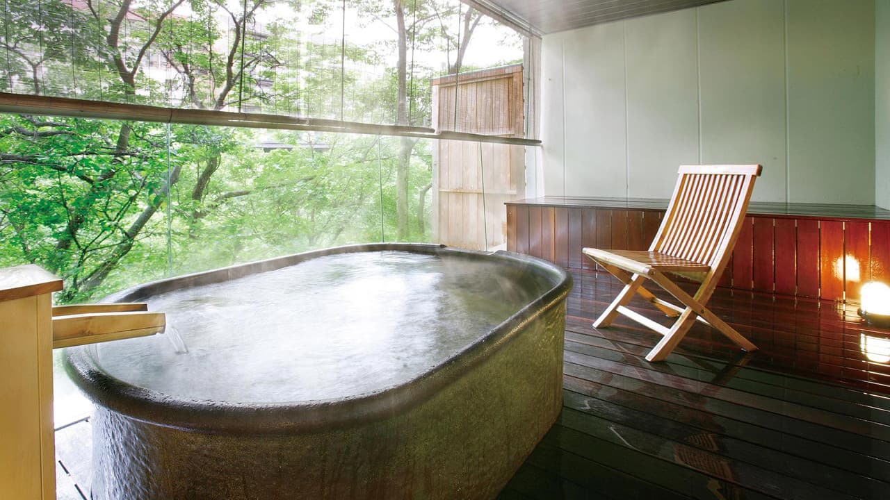 Private open-air bath on a terrace overlooking green forest