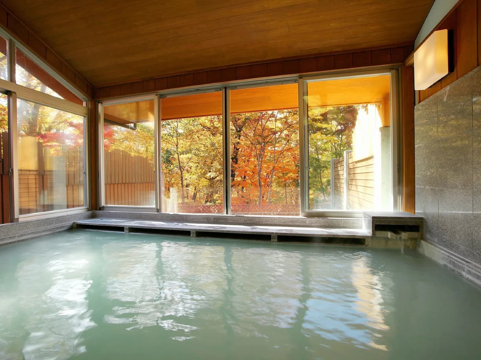 Guest room with beds and a terrace overlooking the wooded valley