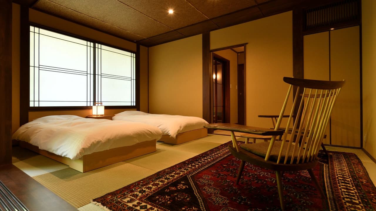 Tatami twin room with a patterned rug and designer chair