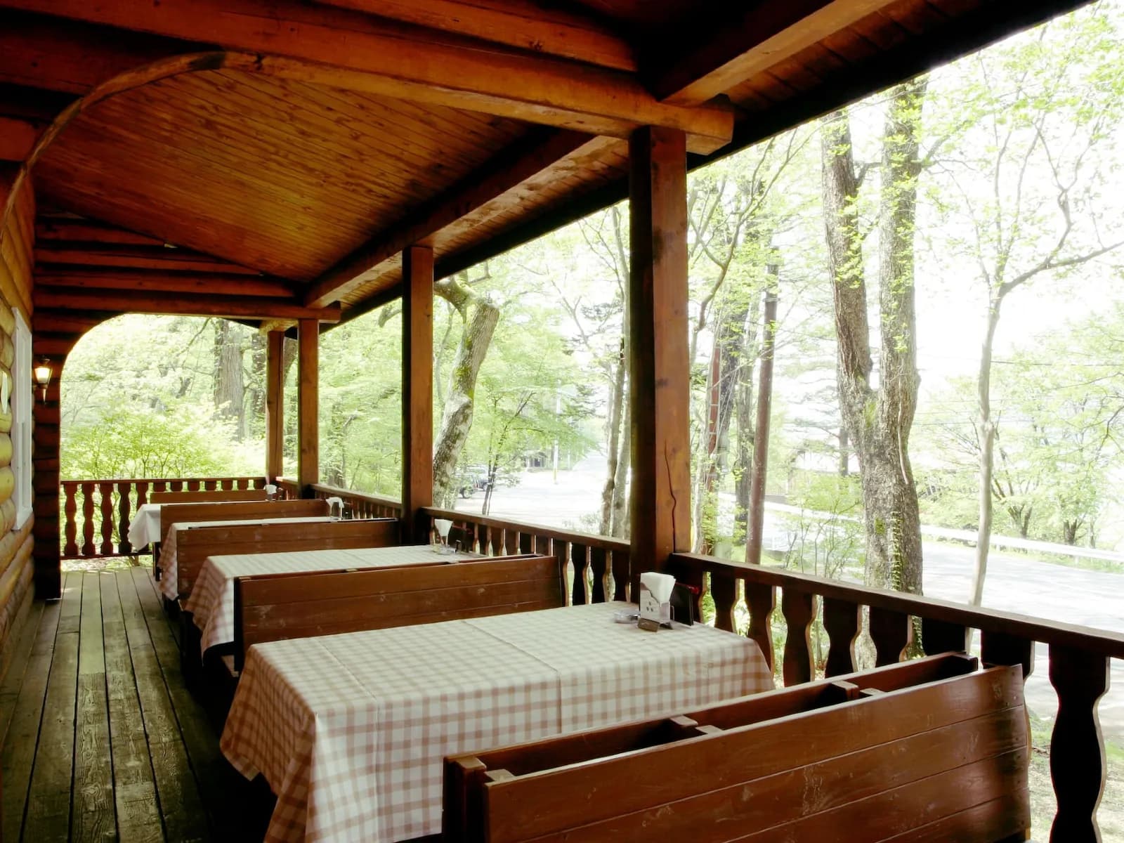 Japanese-style room with rattan chairs facing a green valley view