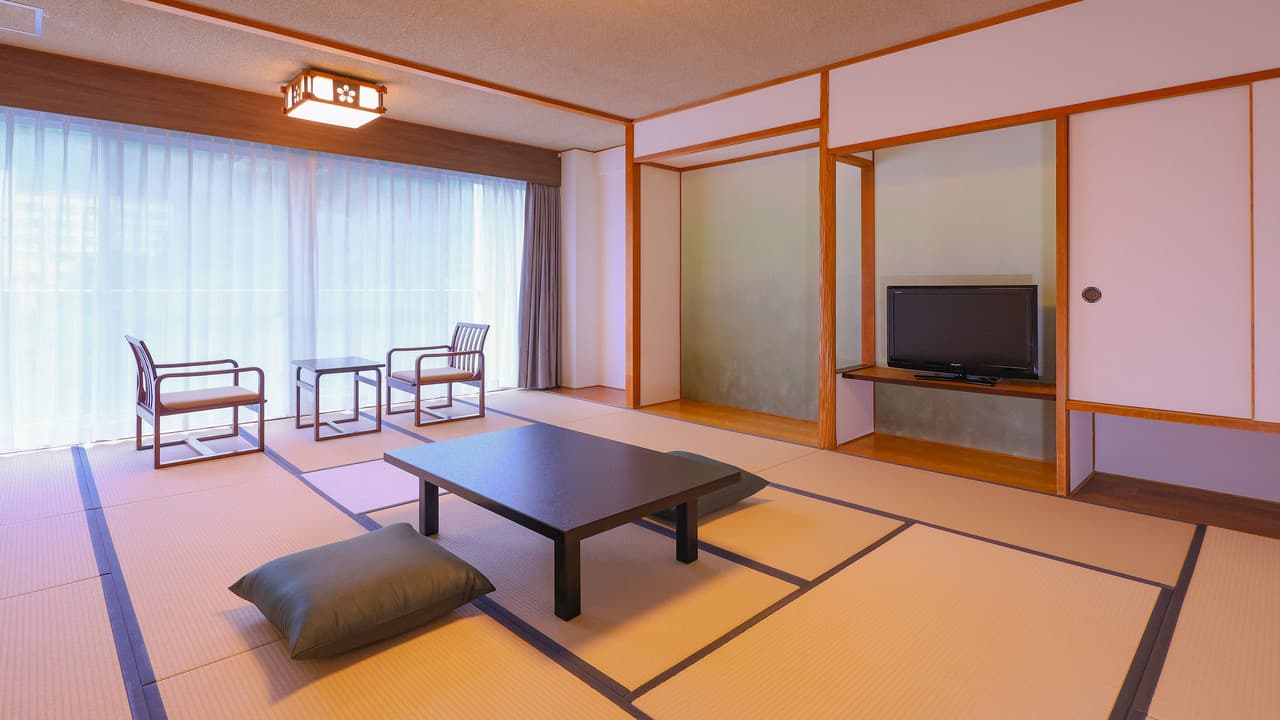 Japanese-style tatami guest room with a low table and floor cushion