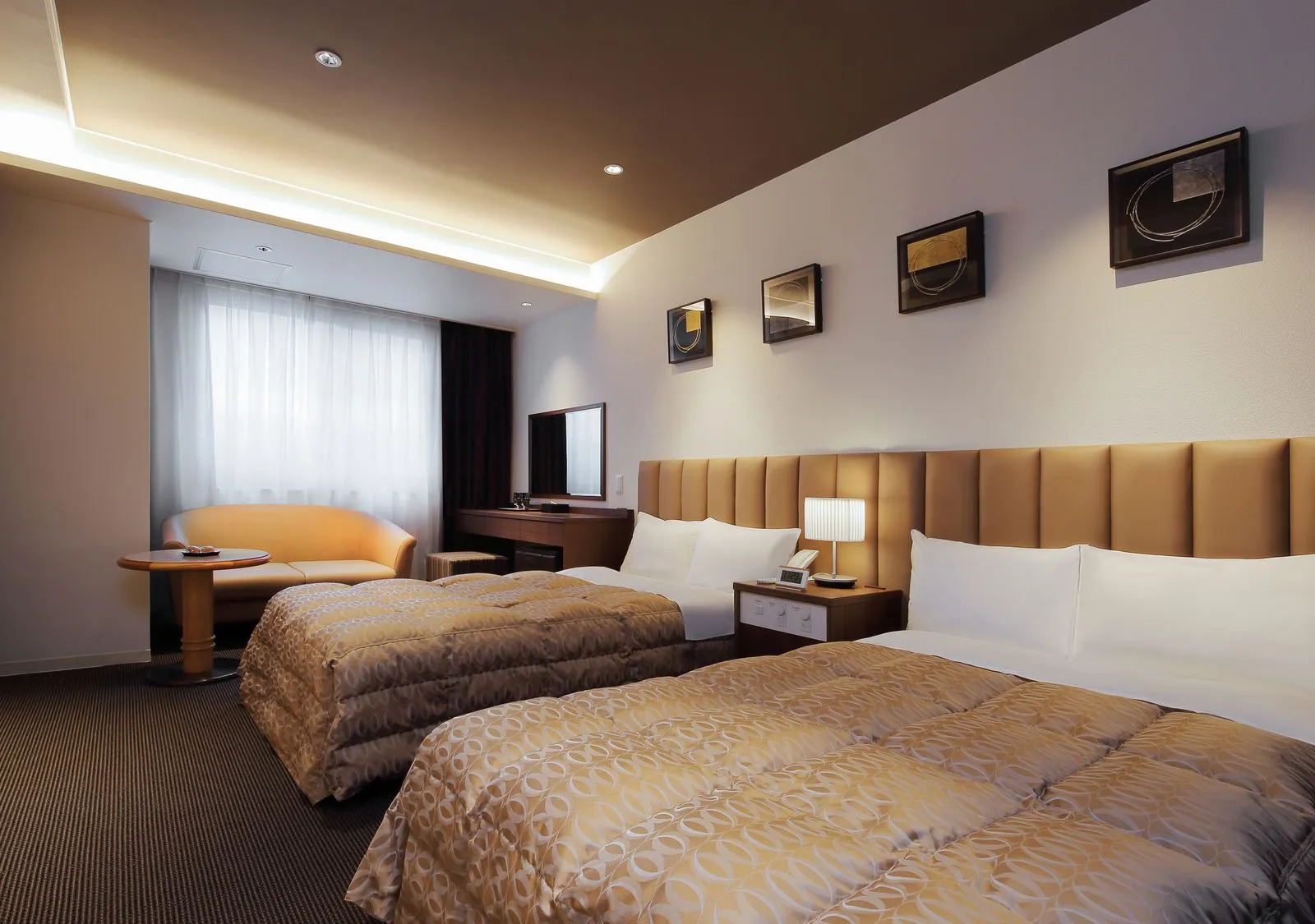 Modern twin room with cushioned headboard and framed artwork