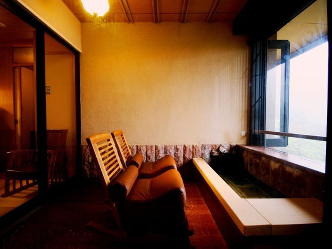 In-room bath with a window view over the forested valley