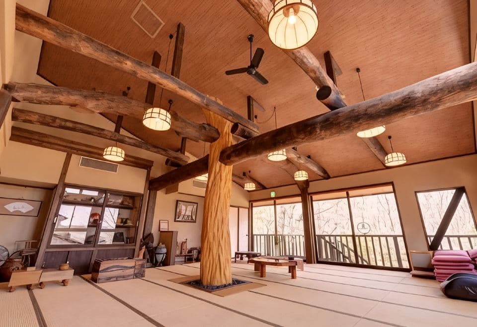 Taisho-era-style tatami hall with massive natural log pillars and paper lanterns