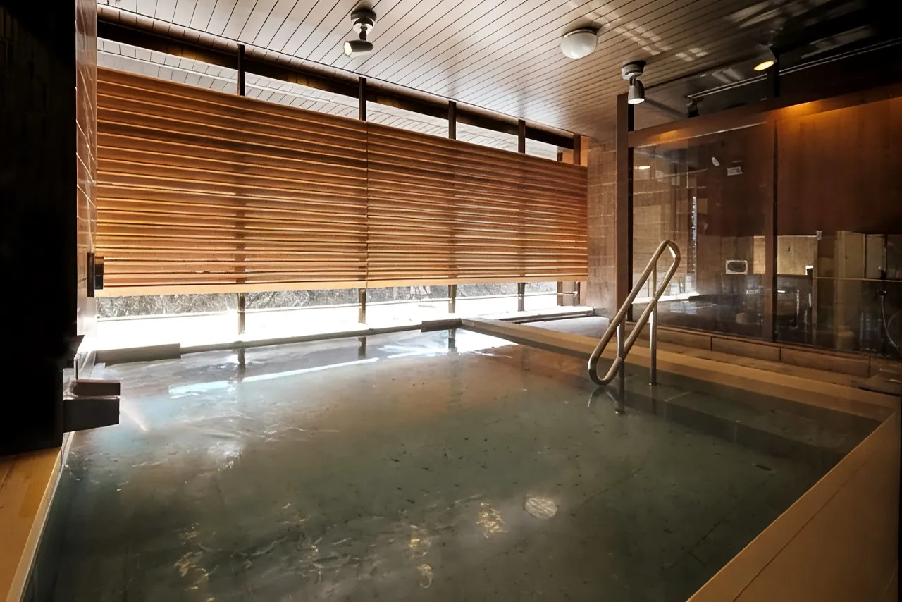 Indoor communal hot spring bath with wood-slatted walls