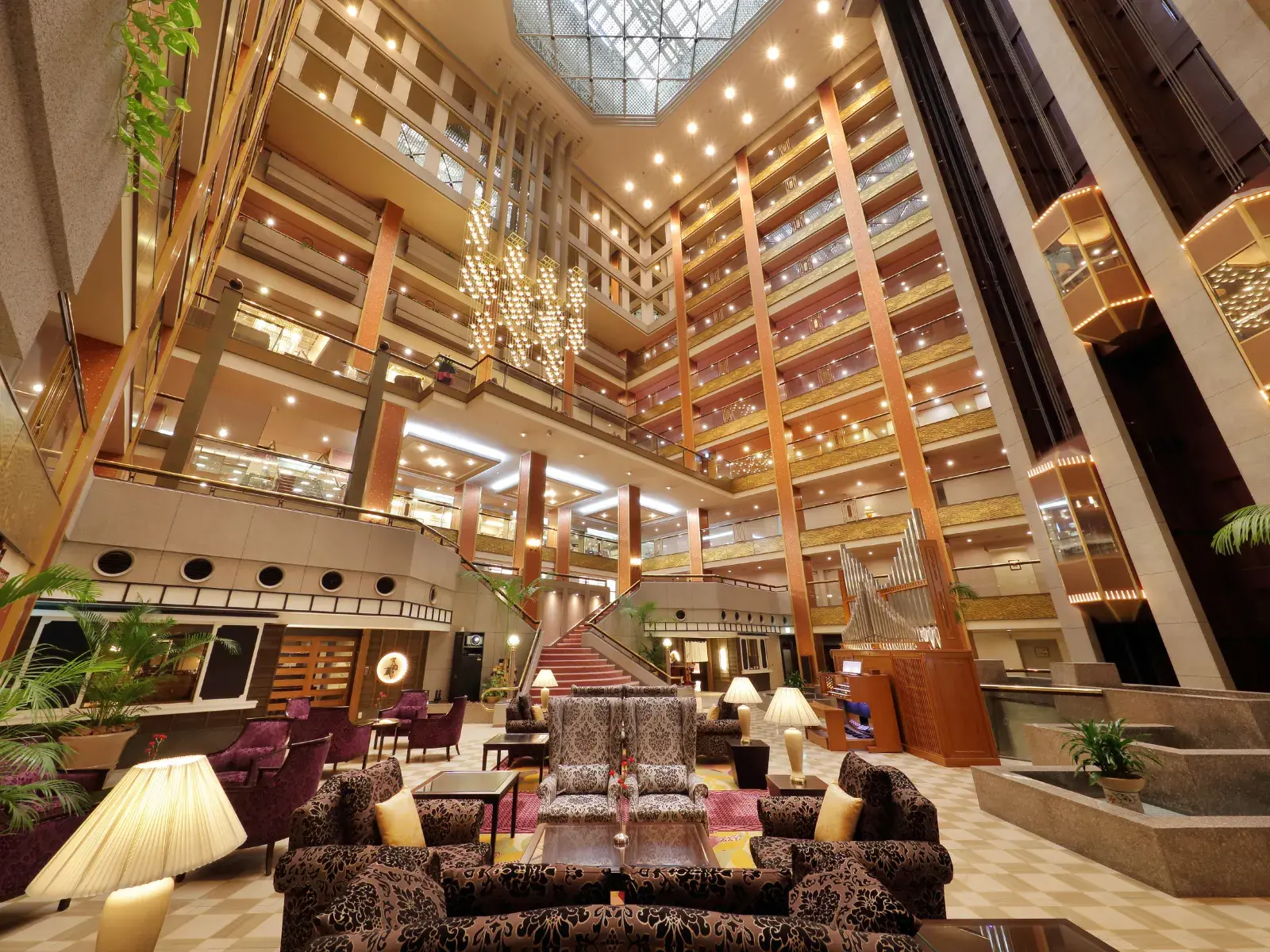 Grand multi-story atrium lobby with chandelier and lounge seating
