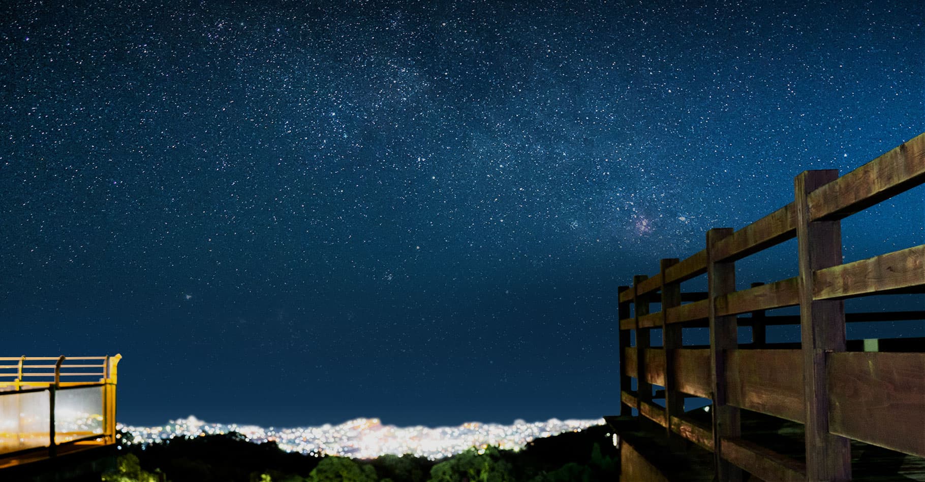 Starry night sky arching over the town lights below the hilltop deck at Bettei Amafuru Oka in Ibusuki