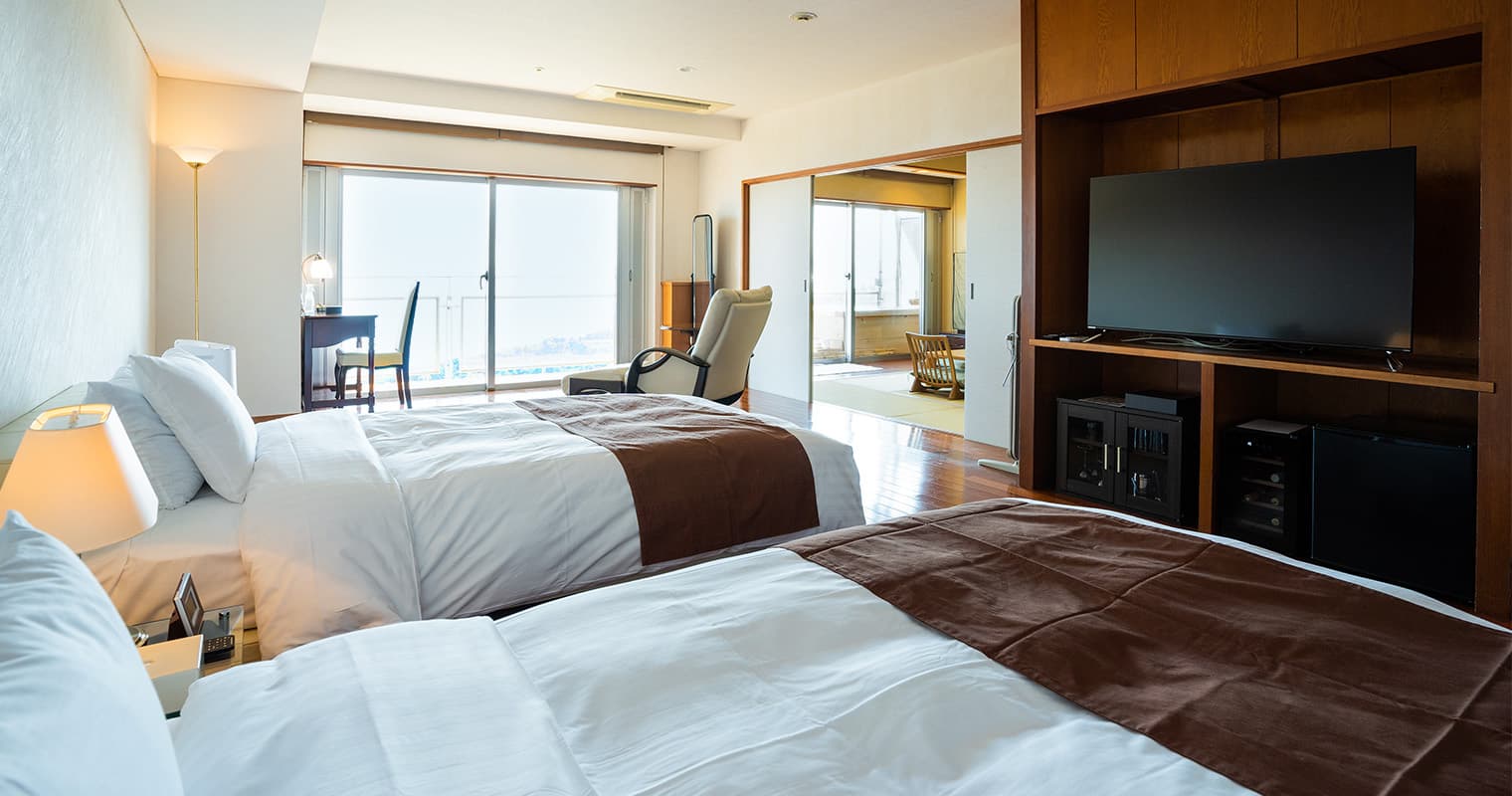 Spacious guest room with twin beds, adjoining tatami area and panoramic bay view at Bettei Amafuru Oka in Ibusuki