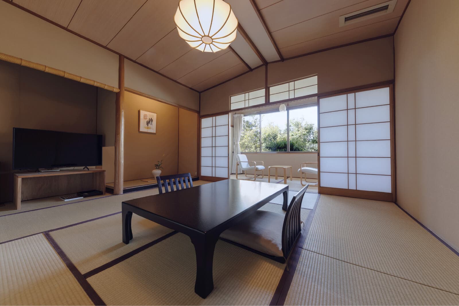 Spacious tatami guest room with a low lacquer table, hanging scroll and mountain-view windows at Takayamaso Hanano, Arima Onsen