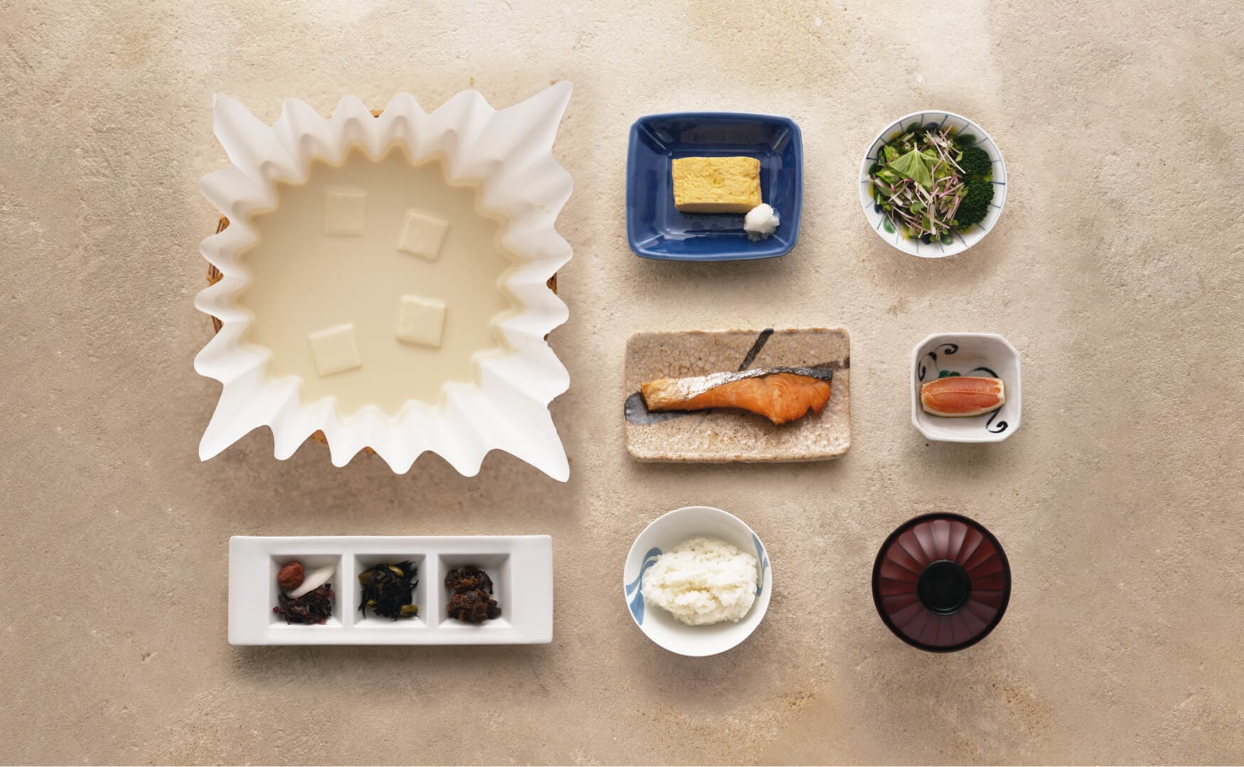 Japanese breakfast set with tofu hotpot, grilled salmon, tamagoyaki and rice arranged overhead at Takayamaso Hanano, Arima Onsen