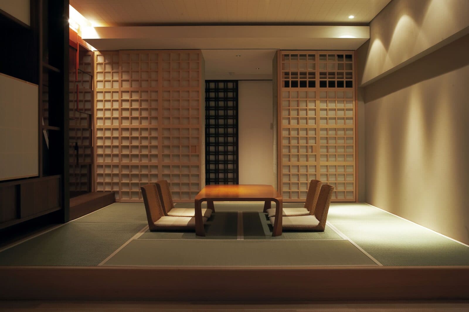 Tatami guest suite with wooden lattice screens and low table seating