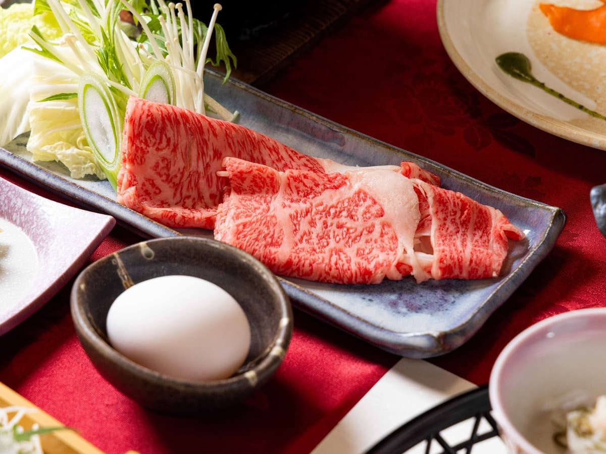Plate of marbled Japanese wagyu beef for shabu-shabu with vegetables and egg at Zenshichinoyu Ohira, Zao Onsen