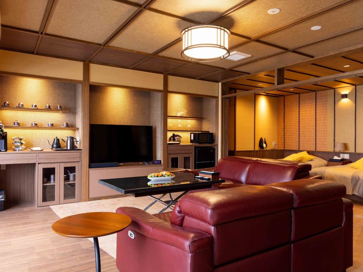 Spacious premium guest room with sitting lounge, low table and twin beds at Zenshichinoyu Ohira, Zao Onsen