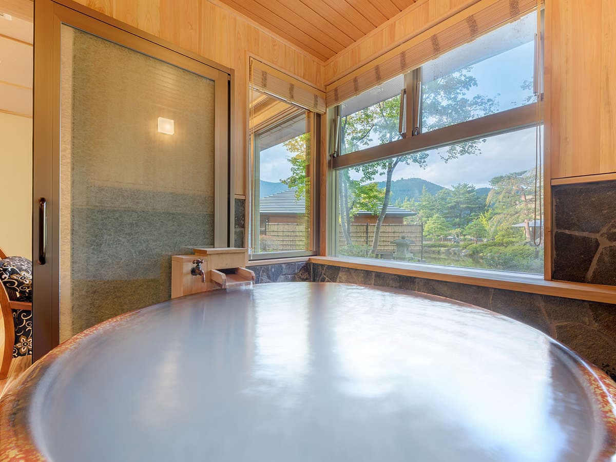 Private in-room cypress soaking tub beside a corner window overlooking the garden and mountains, Yumoto Kissho, Naruko Onsen