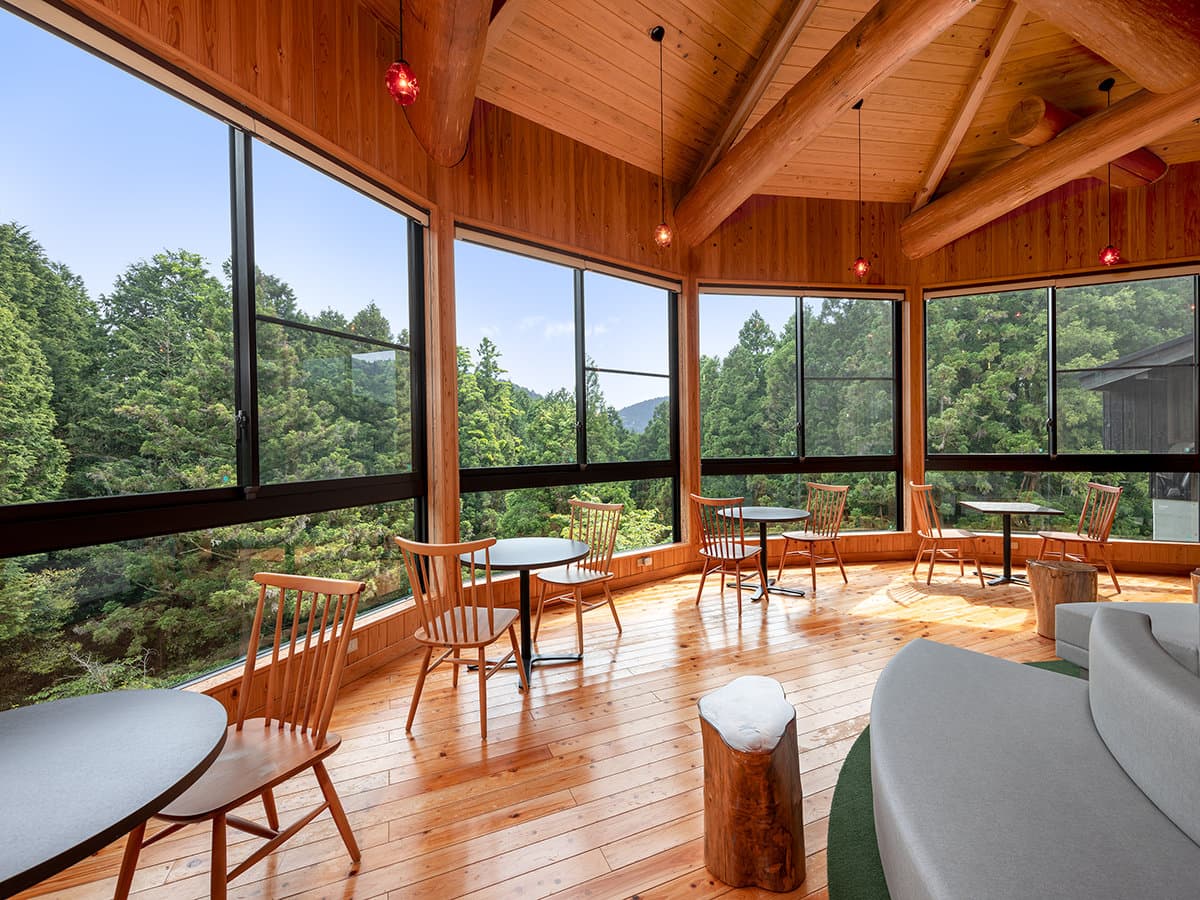 Wood-paneled view lounge at Seiunso with panoramic windows looking out over the forested Unzen hills