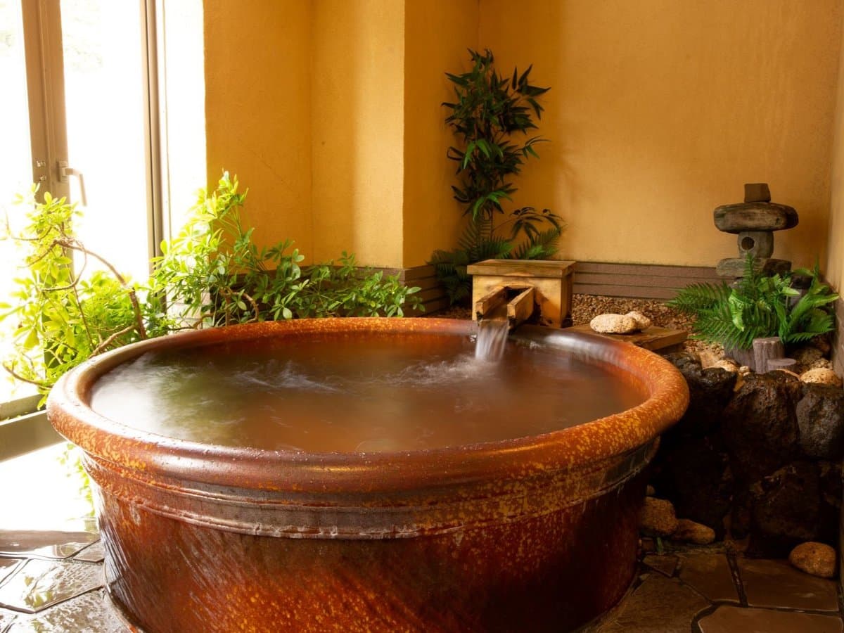 Stone open-air soaking tub at Oyado Seri set in a small garden