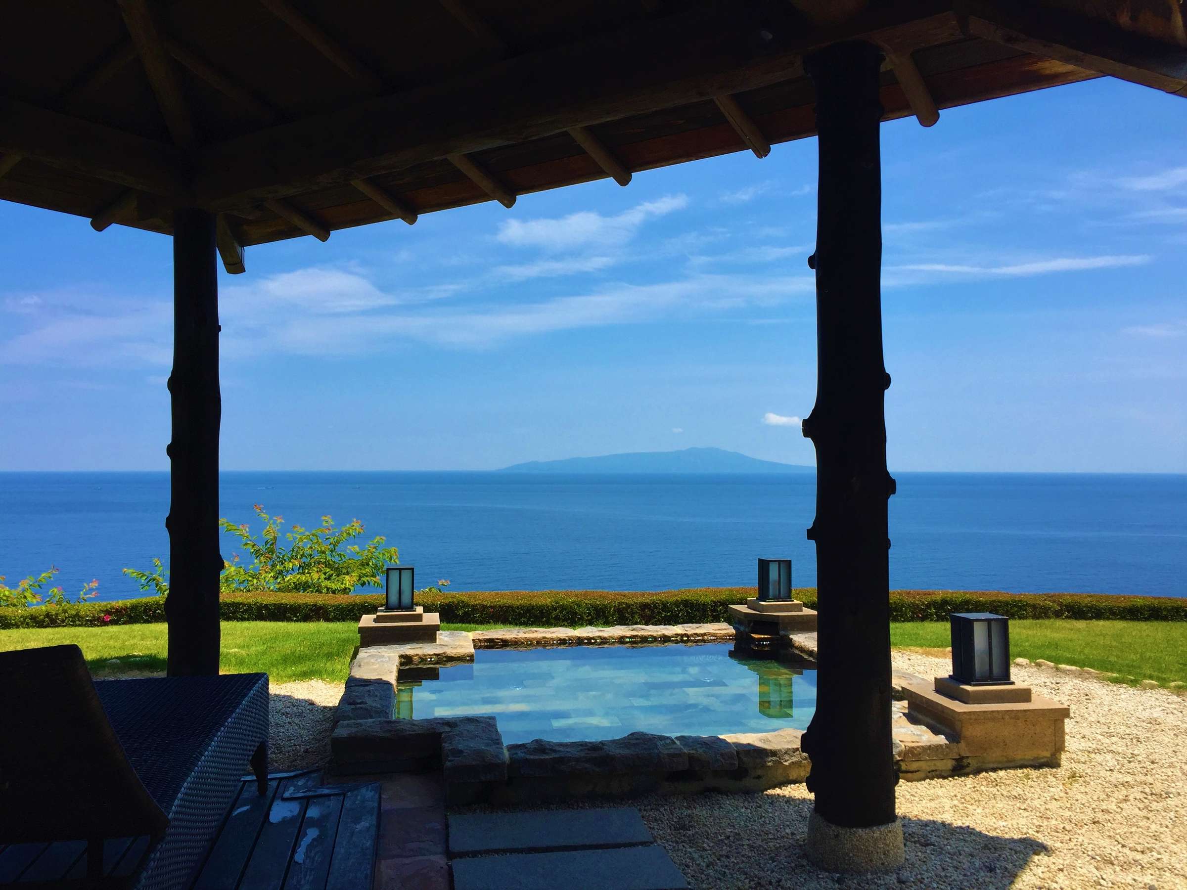 Daytime open-air bath with stone-lantern terrace and panoramic blue ocean view at Tsuki no Usagi, Izu