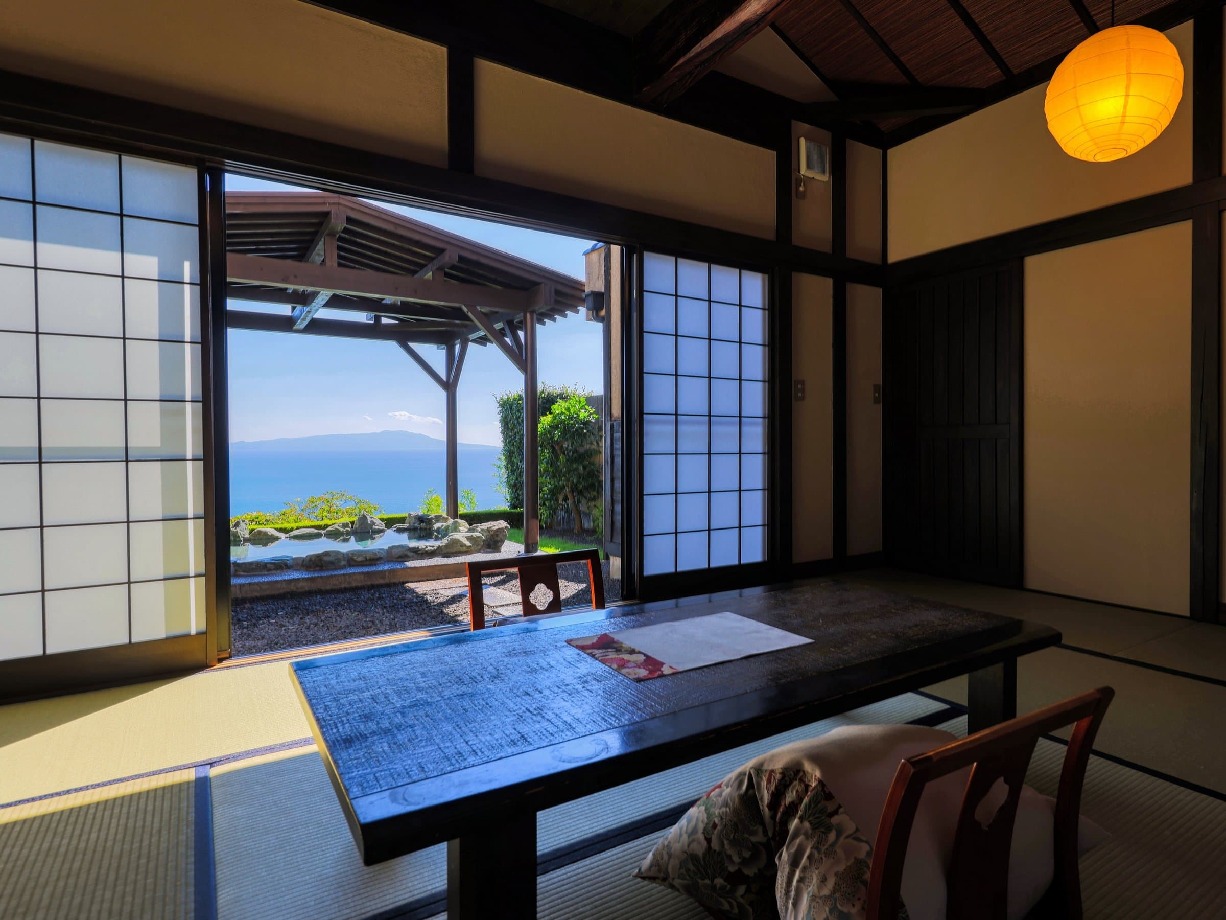 Tatami guest room framing a sweeping Sagami Bay view through open shoji doors at Tsuki no Usagi, Izu