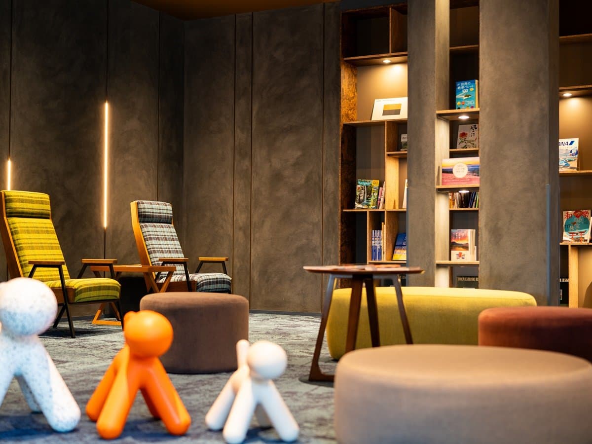 Yusai library lounge with bookshelves, lounge chairs and ottomans