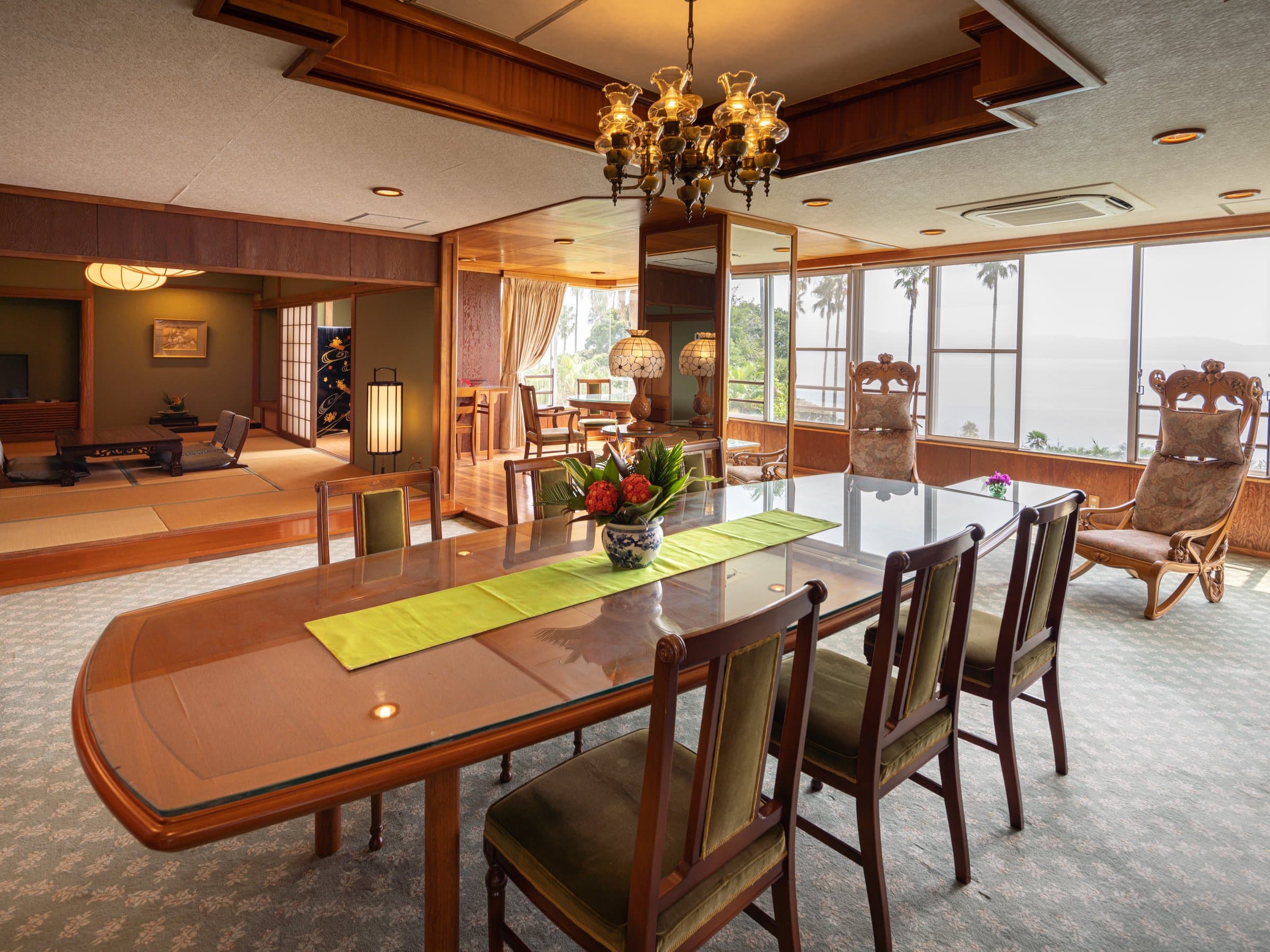 Spacious Japanese-Western suite at Ibusuki Phoenix Hotel with dining table and wraparound ocean-view windows
