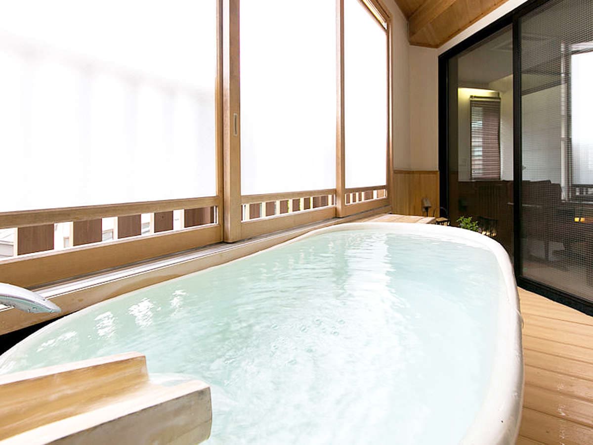Private guest-room hinoki bath at Hakuba Hifumi beside a bright wood-framed window