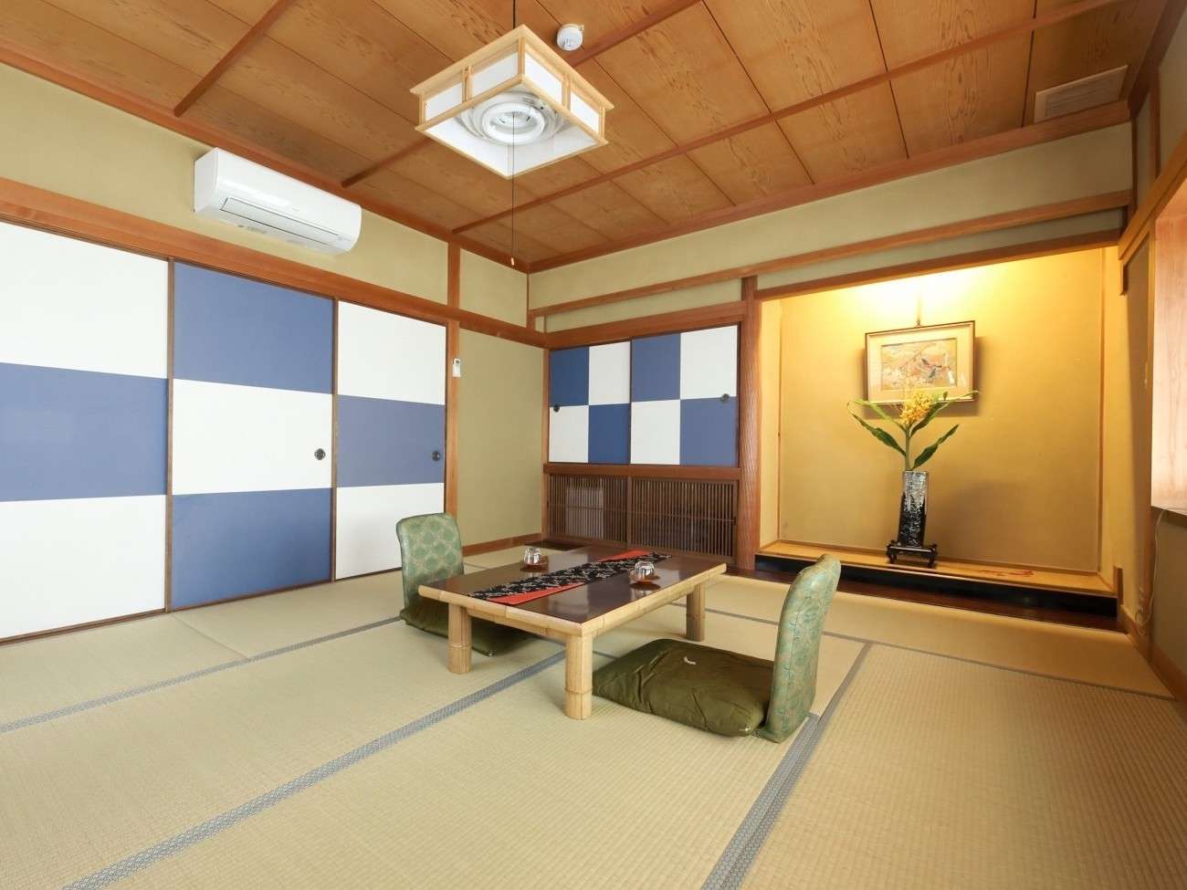 Japanese guest room at Fujimiya with checkered accent wall and tatami flooring