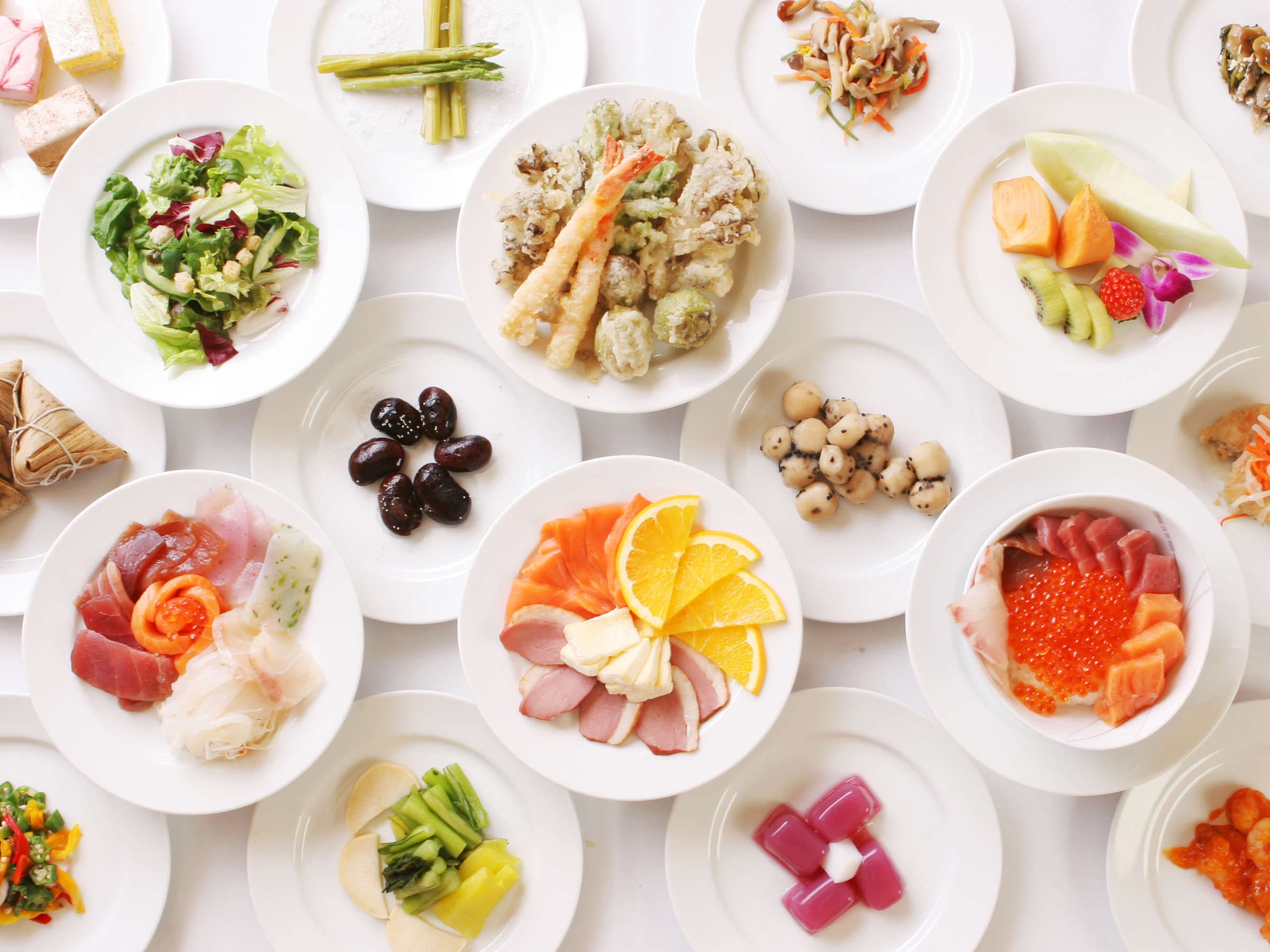 Kusatsu Now Resort Hotel buffet spread photographed from above, white plates of sashimi, tempura, salad and side dishes