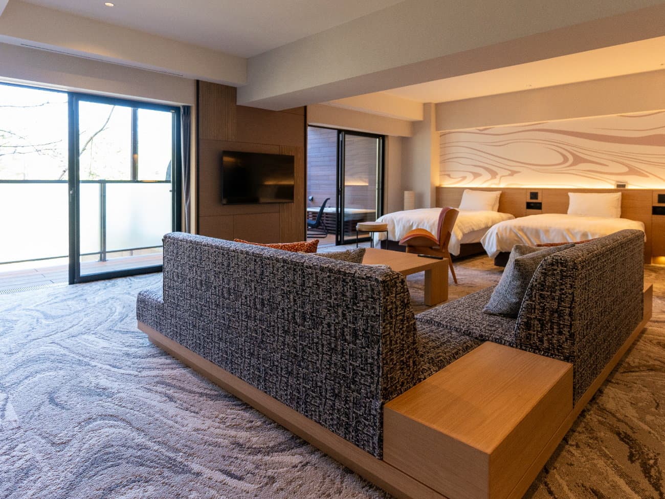 Kusatsu Now Resort Hotel renovated twin suite with wave-pattern headboard, lounge sofas and a private terrace