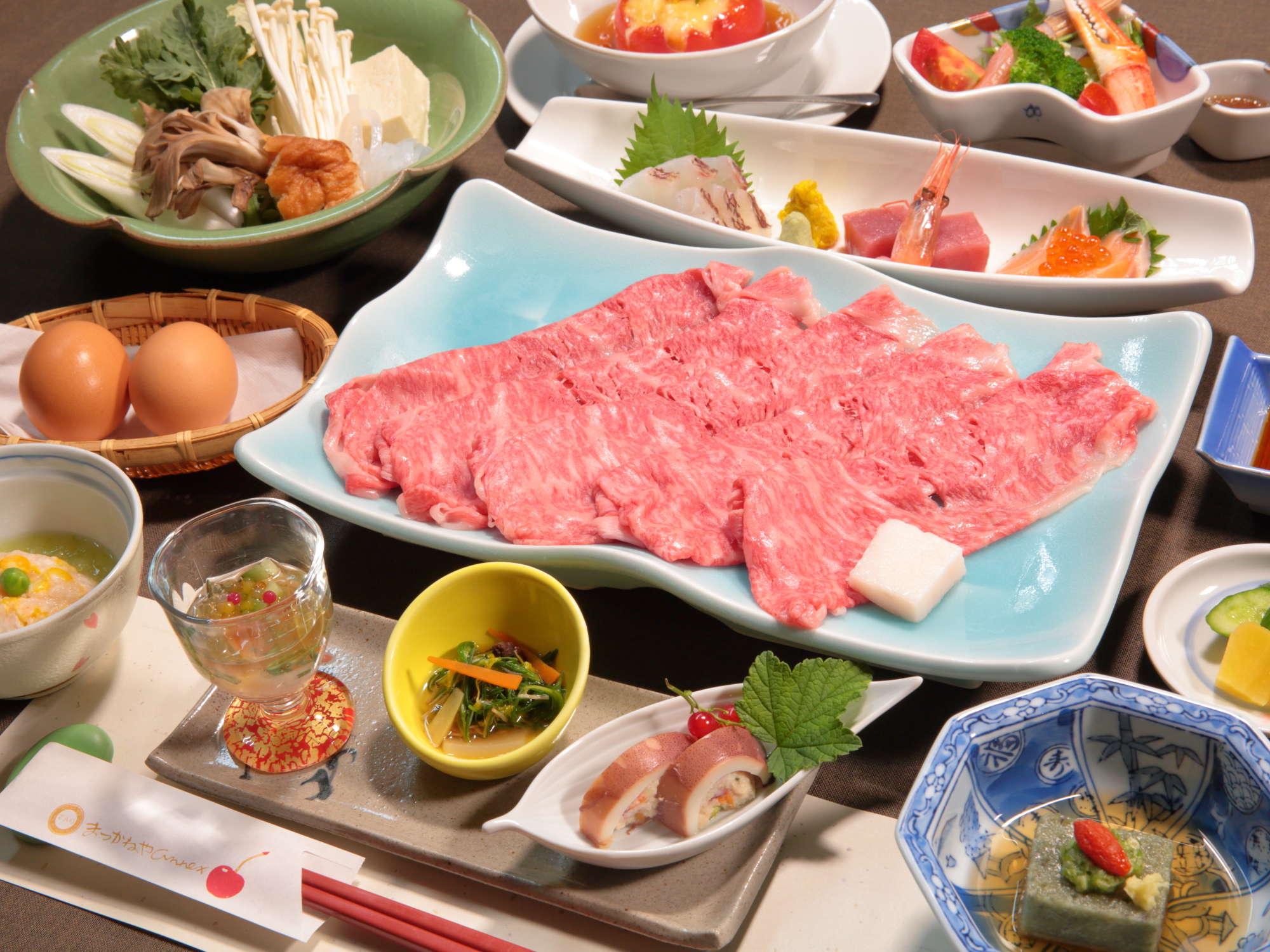 Kaiseki dinner set featuring marbled beef for hot pot, sashimi and assorted seasonal side dishes