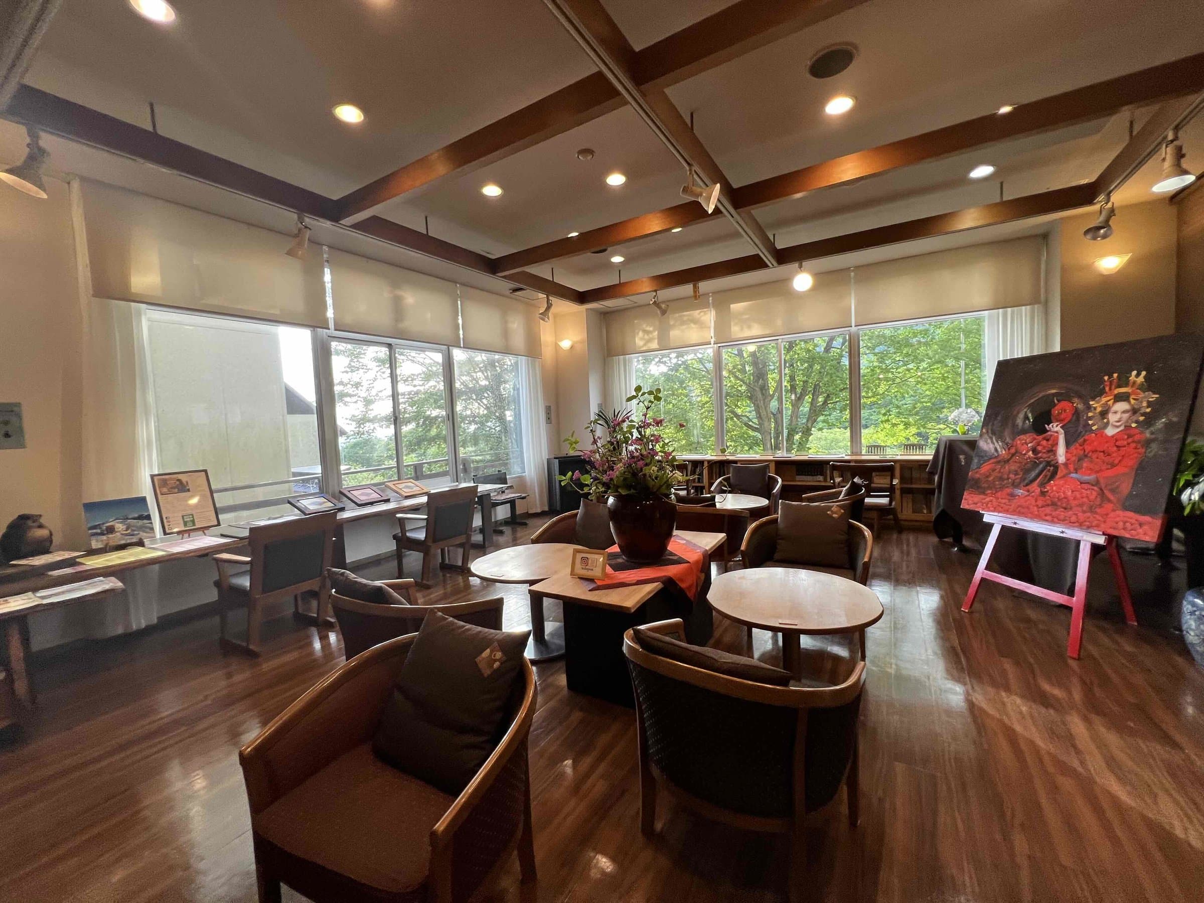 Wood-toned lobby lounge with armchairs, large windows and a coffered ceiling at Hotel Matsukaneya Annex