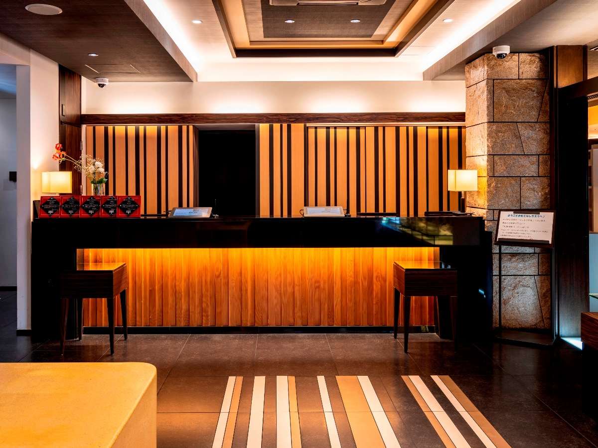 Front desk reception of Hotel Dogo Yaya with warm wood paneling and stone pillar accents