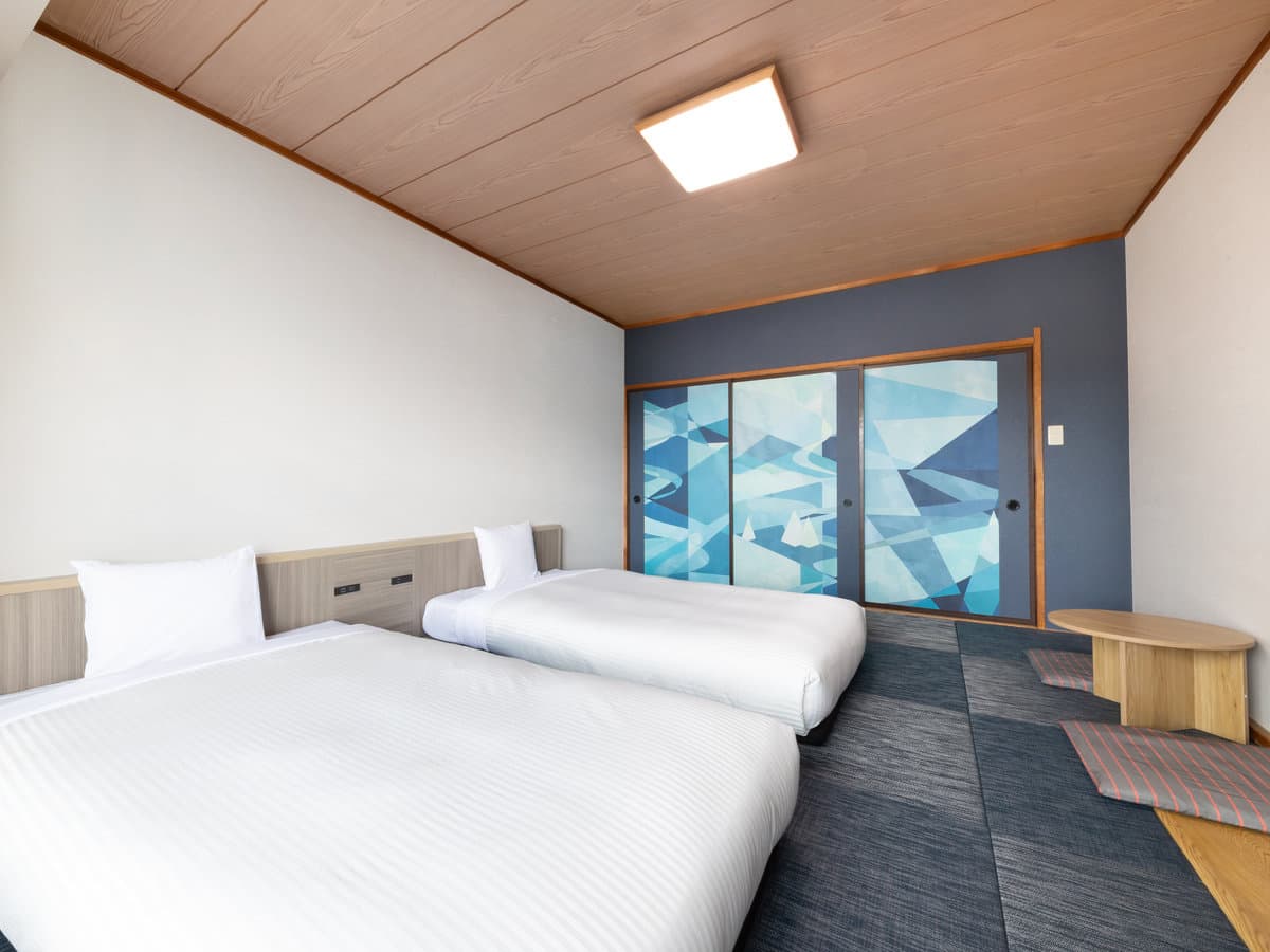 Deluxe Japanese-style twin room with low beds and blue abstract-art sliding doors