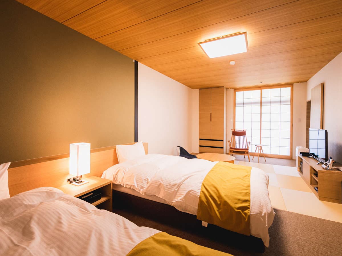 Modern Japanese-style twin bedroom at Hotel Tsubakikan with wood ceiling and shoji-paper sliding doors