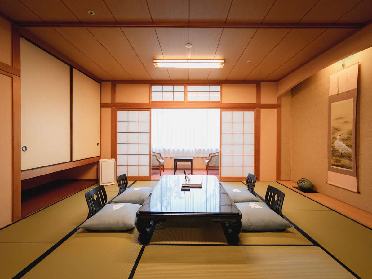 Traditional tatami guest room at Hotel Tsubakikan with low table, hanging scroll and shoji-screened window