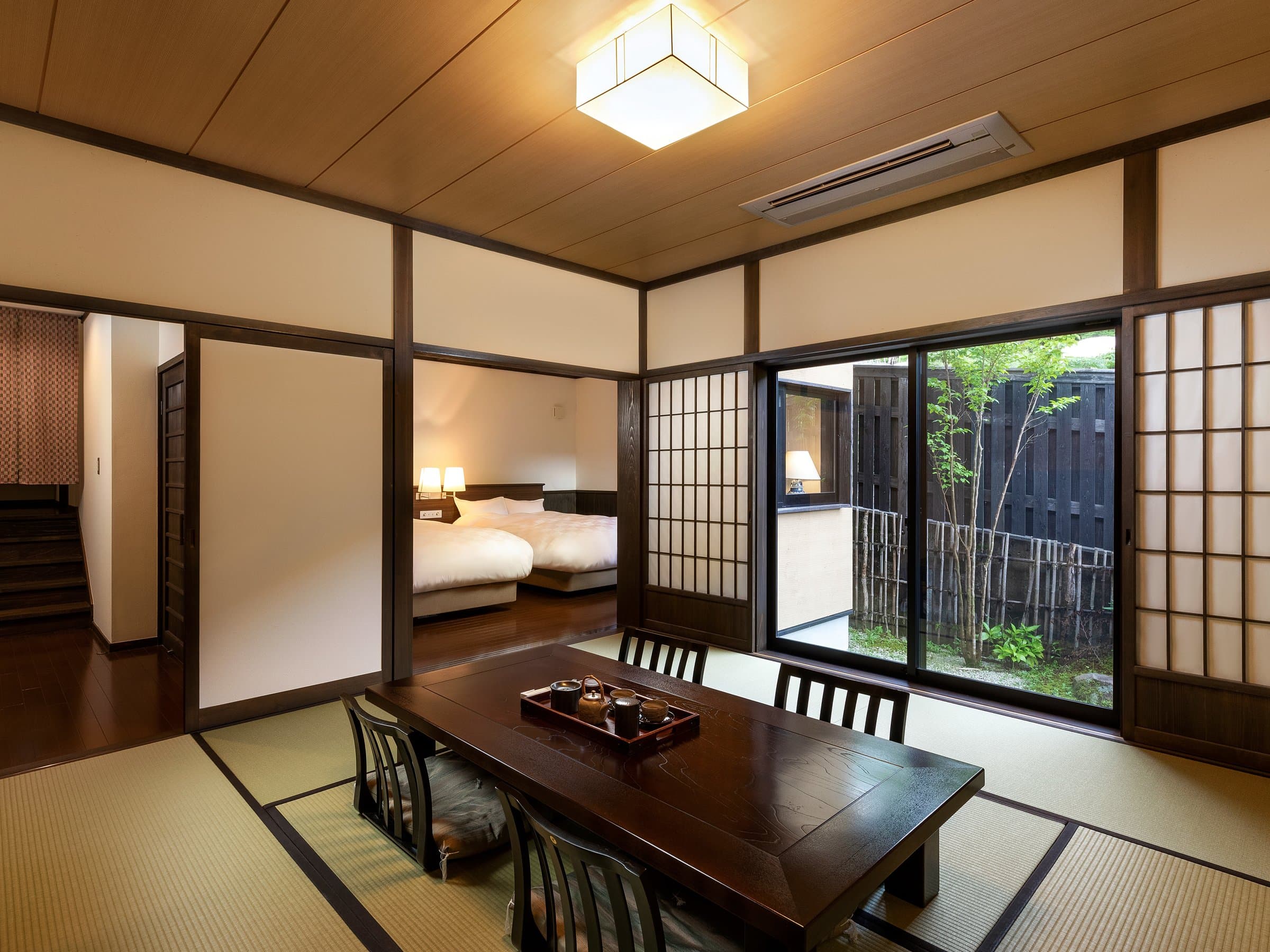 Spacious tatami guest room at Yufuin Yufusaryo with shoji screens and garden-facing windows