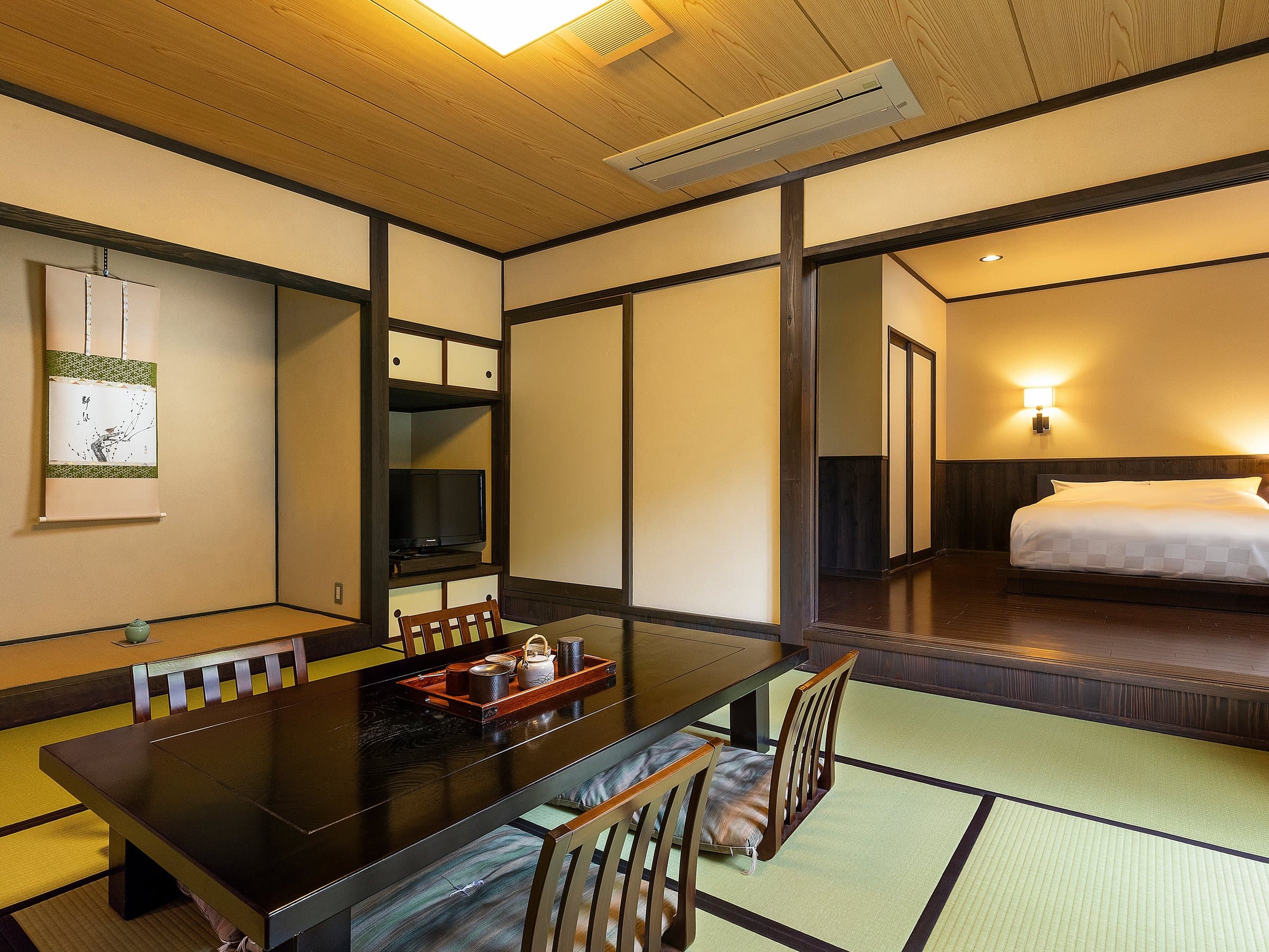 Japanese-style guest room at Yufuin Yufusaryo with a low table seating area and adjoining bedroom alcove