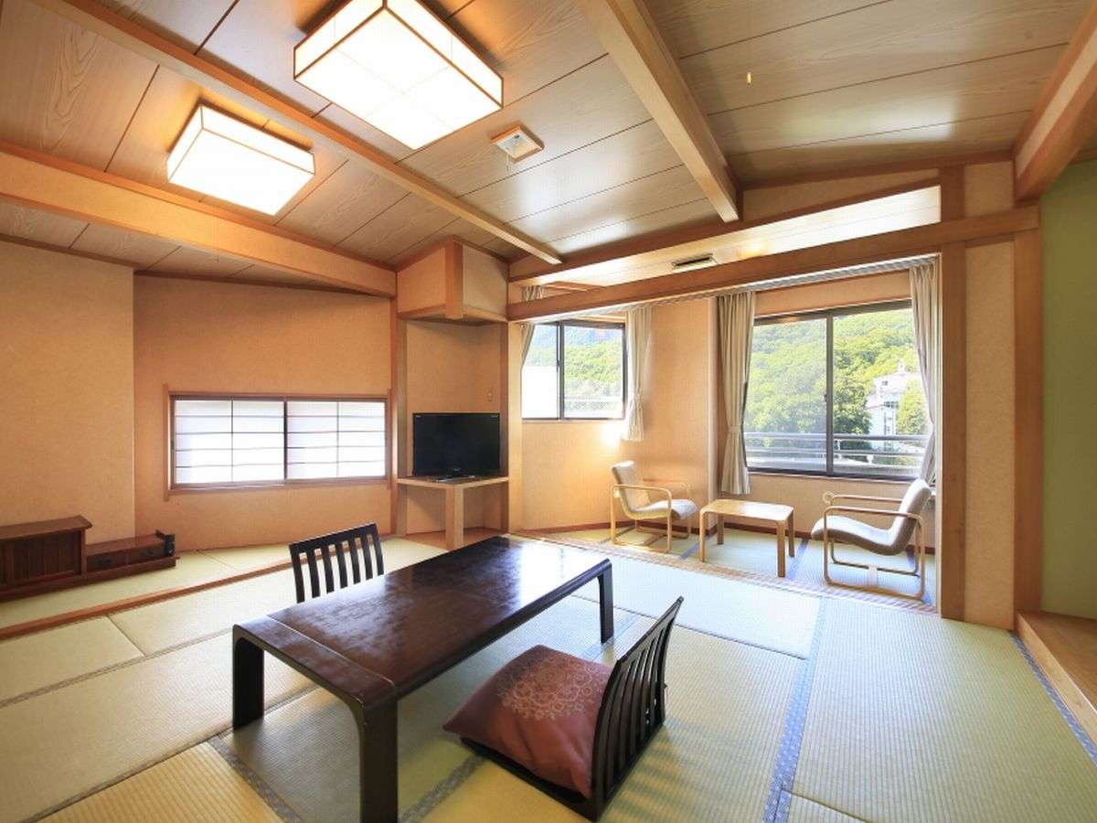 Spacious tatami guest room with low table and forest view at Zao Plaza Hotel
