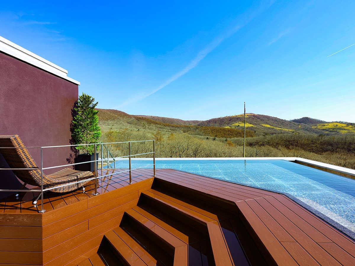 Rooftop open-air bath with wooden deck and loungers facing the Nikko hills at TAOYA Nikko Kirifuri