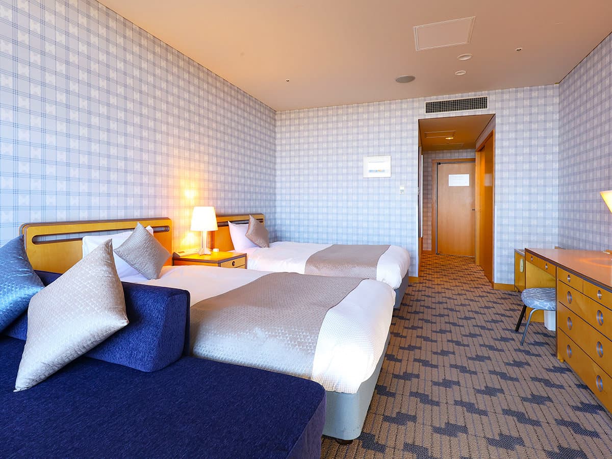 Twin bedroom with patterned carpet and bedside lamp at TAOYA Nikko Kirifuri in Nikko