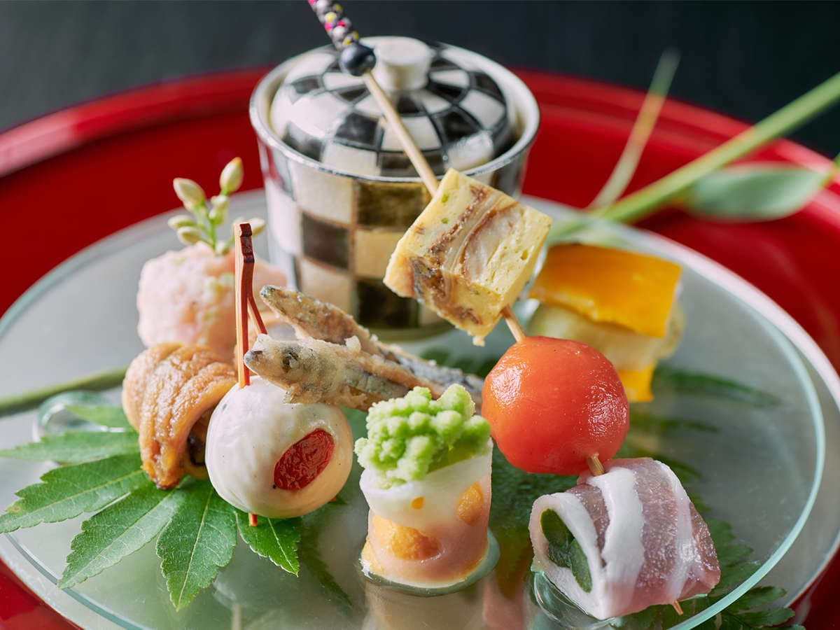 Assorted kaiseki appetizer skewers and small bites artfully plated on glass at Hyakurakuso, Yuwaku Onsen