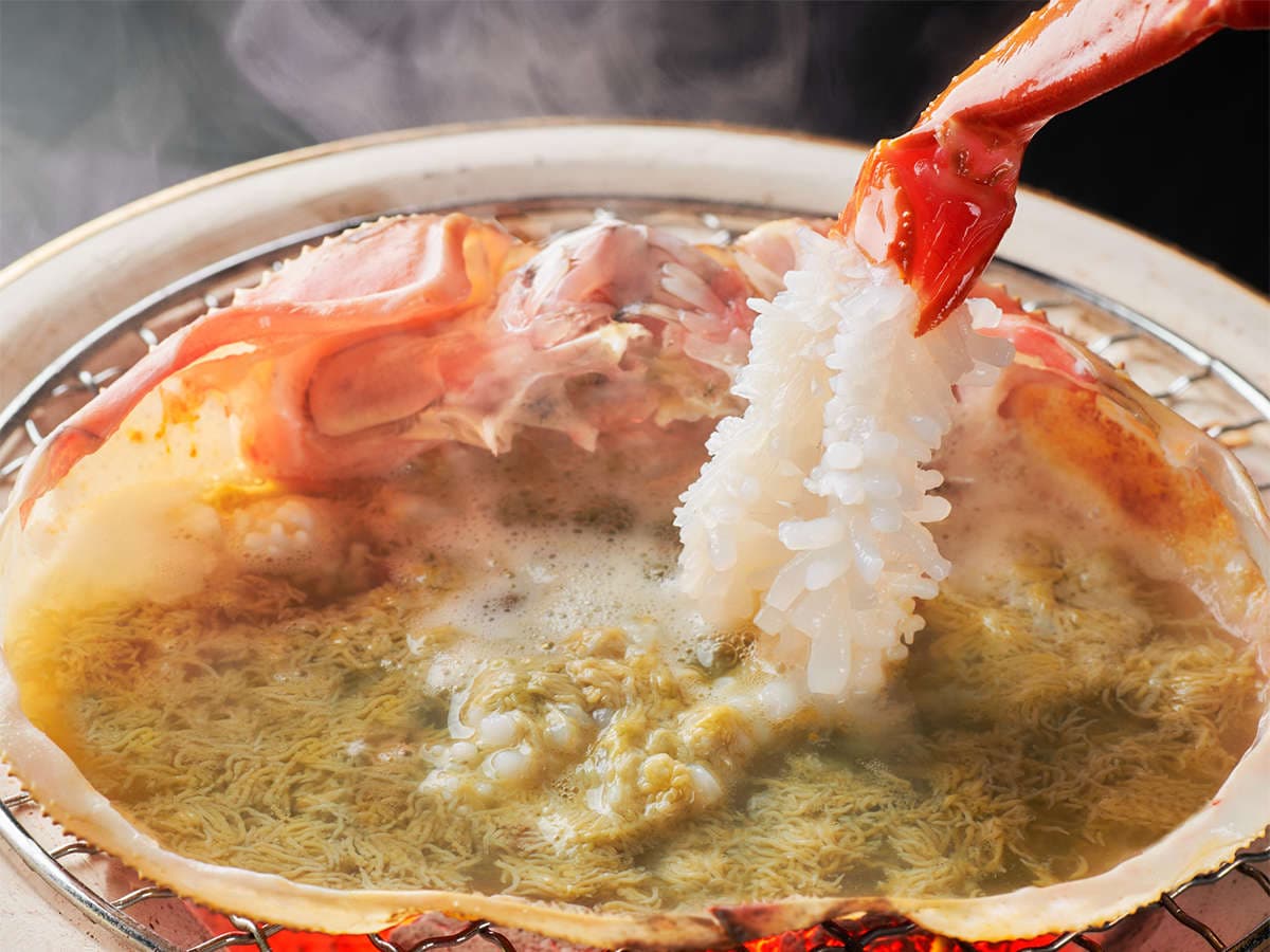 Steaming crab and seafood hot pot simmering over flame at Kanazawa Yuwaku Onsen Hyakurakuso
