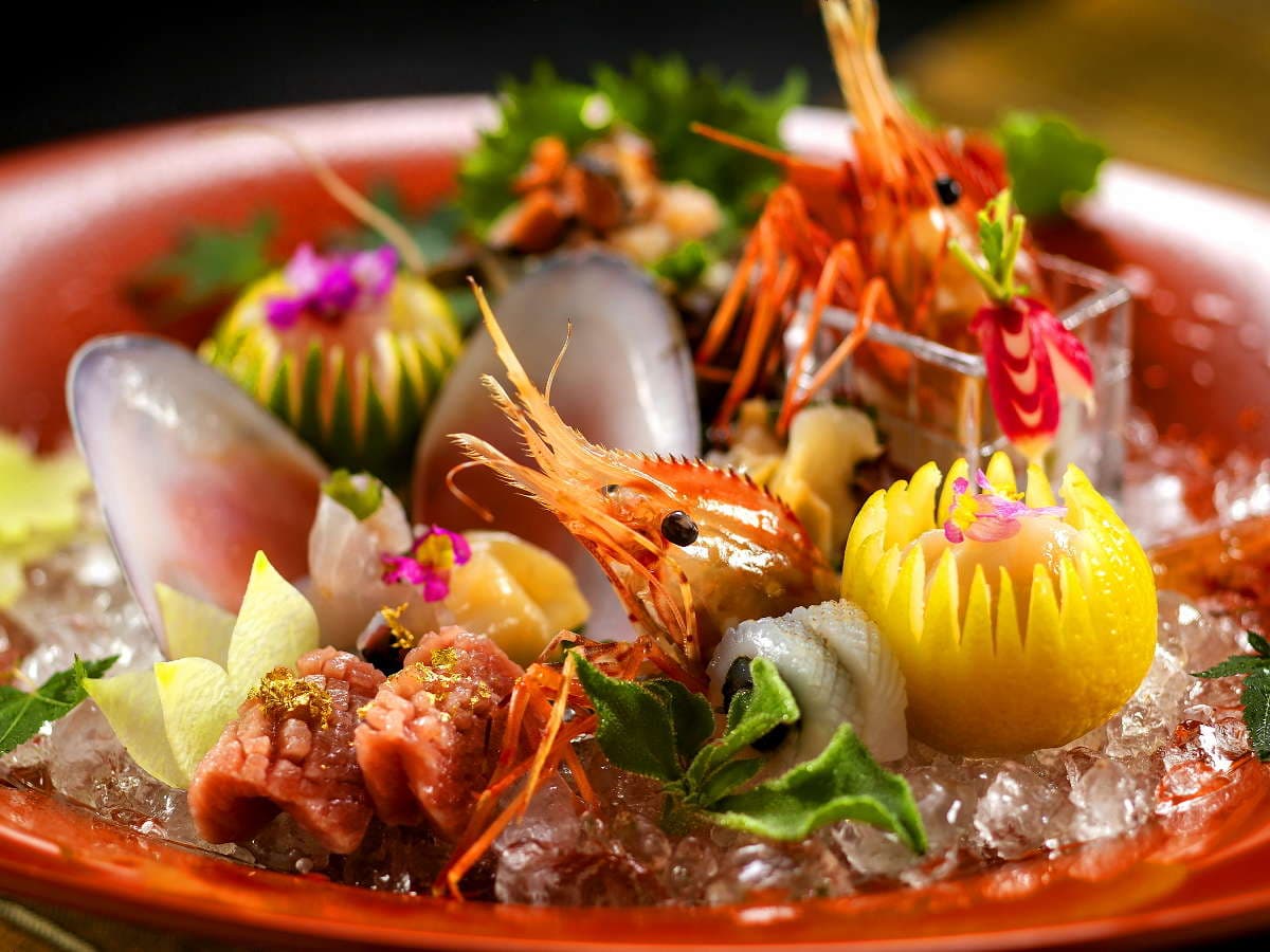 Lavish seafood sashimi platter with prawns, shellfish and edible flowers on ice at Hyakurakuso, Yuwaku Onsen