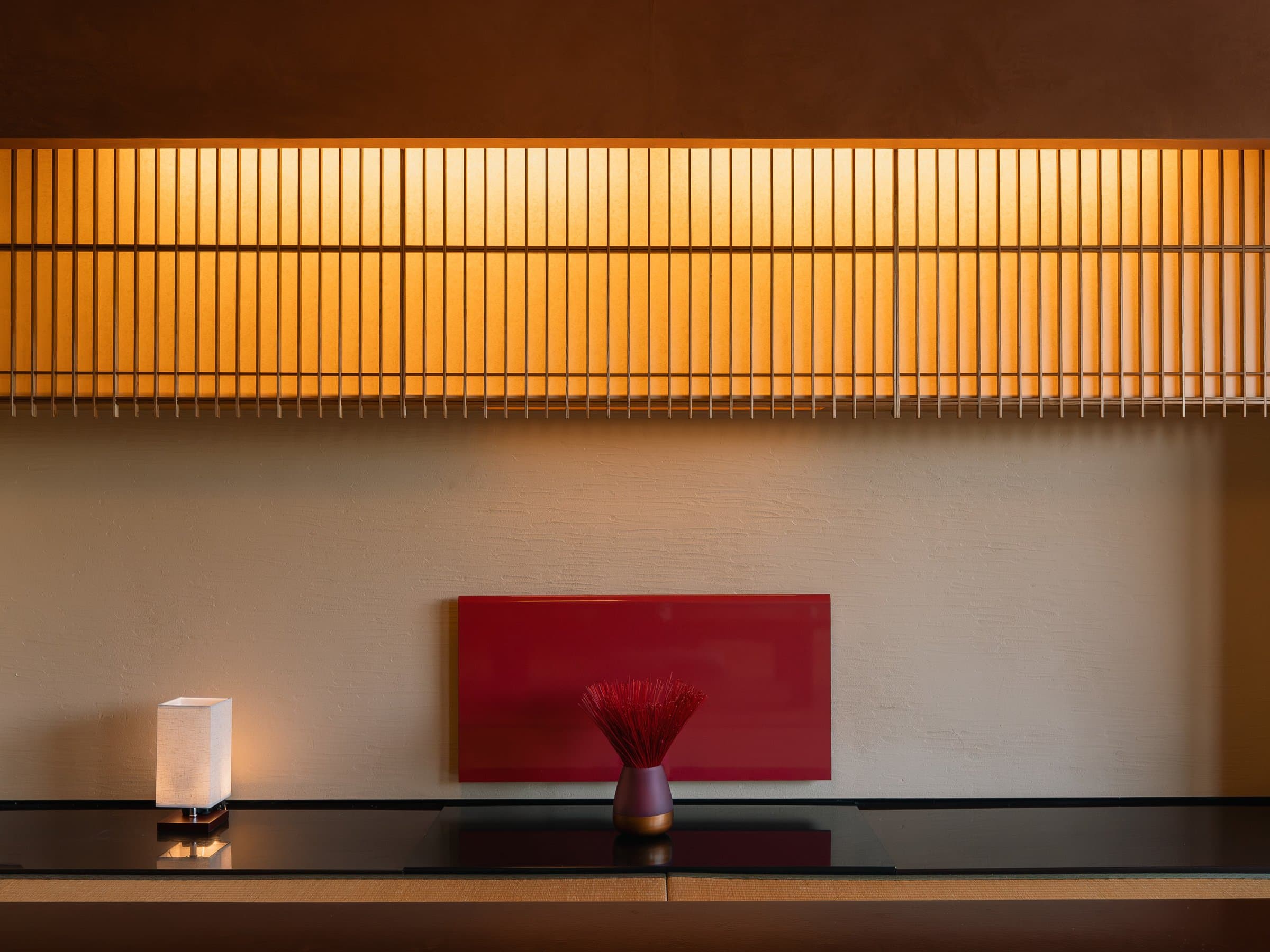Modern guest room with low-lit lattice panel, vanity counter and large windows at Hotel Higuchiken
