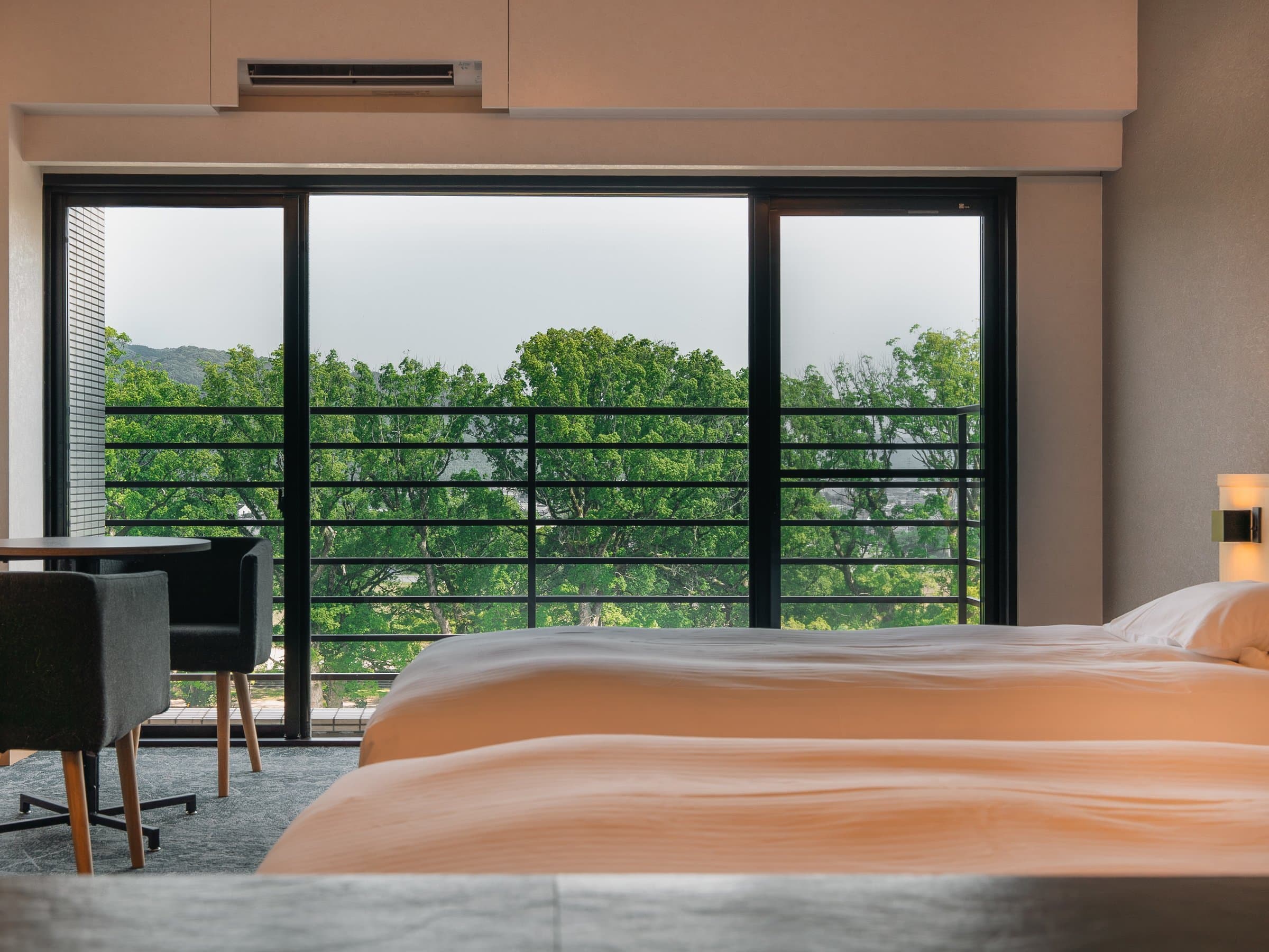 Spacious tatami Japanese-style room with sunken seating and green riverside view at Hotel Higuchiken