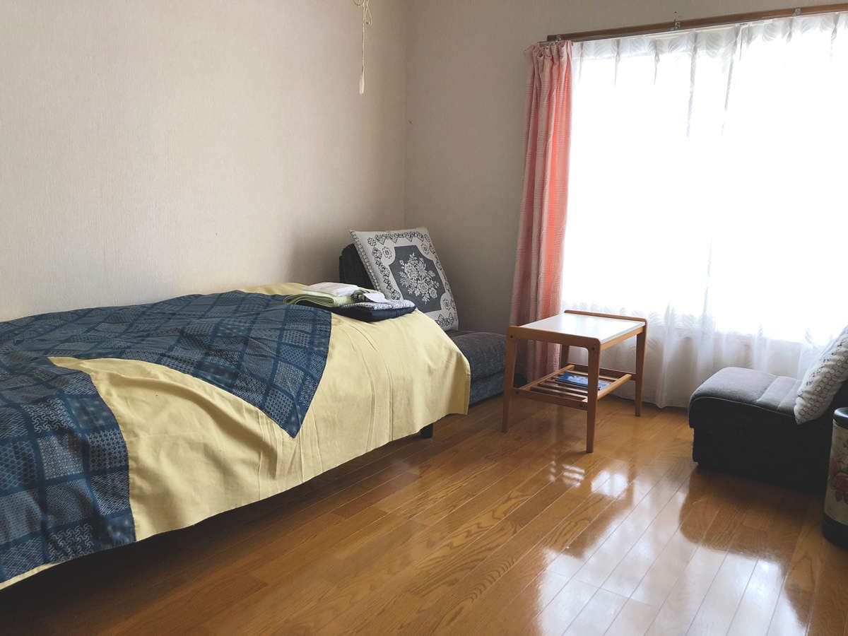 Western-style single bedroom at Ryokan Furuya with bed, side table and bright curtained window