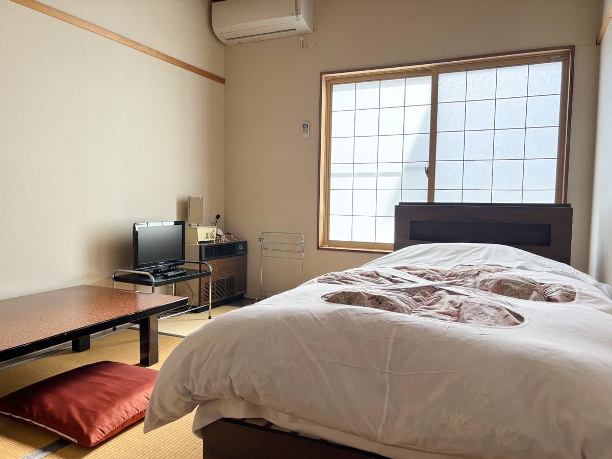 Japanese-Western guest room at Ryokan Furuya with a double bed on tatami and a low table