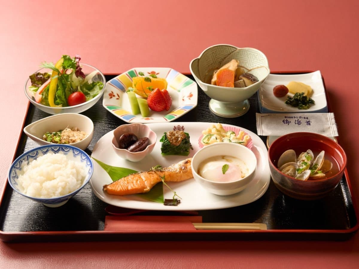 Japanese breakfast set with grilled salmon, rice, miso clam soup and small side dishes on a lacquer tray
